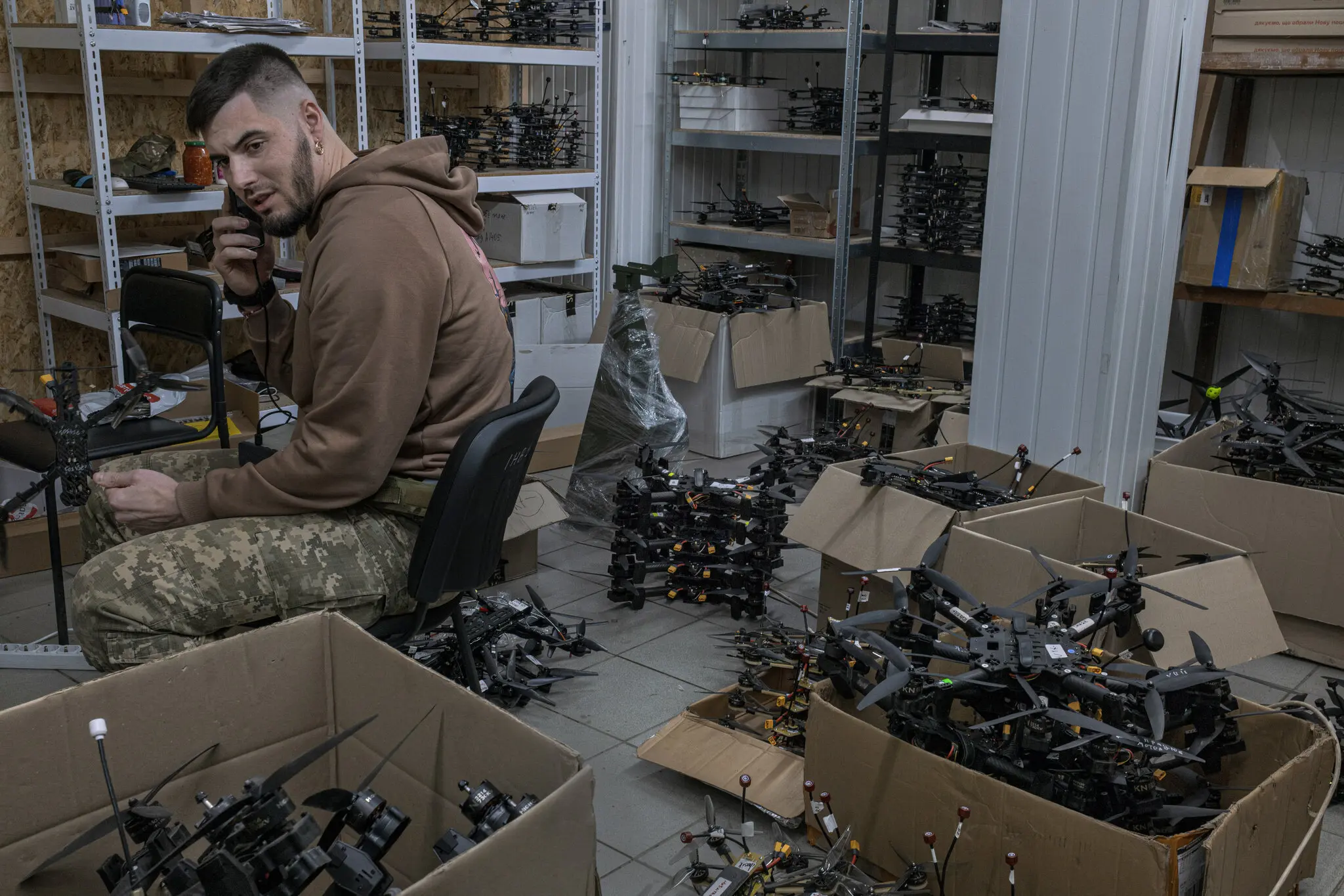 Керівник найефективнішого підрозділу безпілотників української армії «Ахілл» у своїй майстерні на Донеччині в оточенні арсеналу безпілотних літальних апаратів, які використовуються у боротьбі з російськими військами.